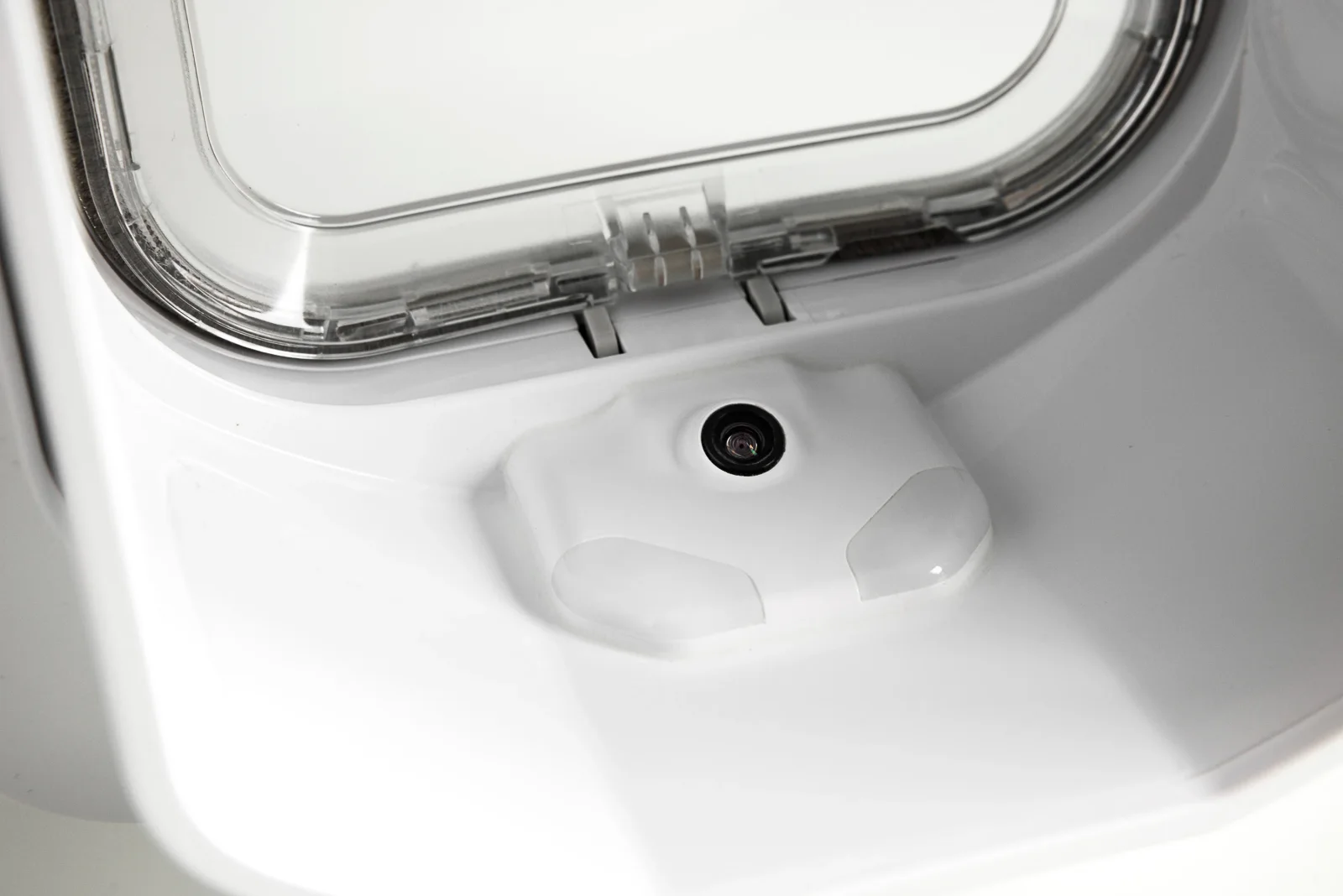 Close-up photograph of OnlyCat’s camera beneath the clear flap, watching the entrance