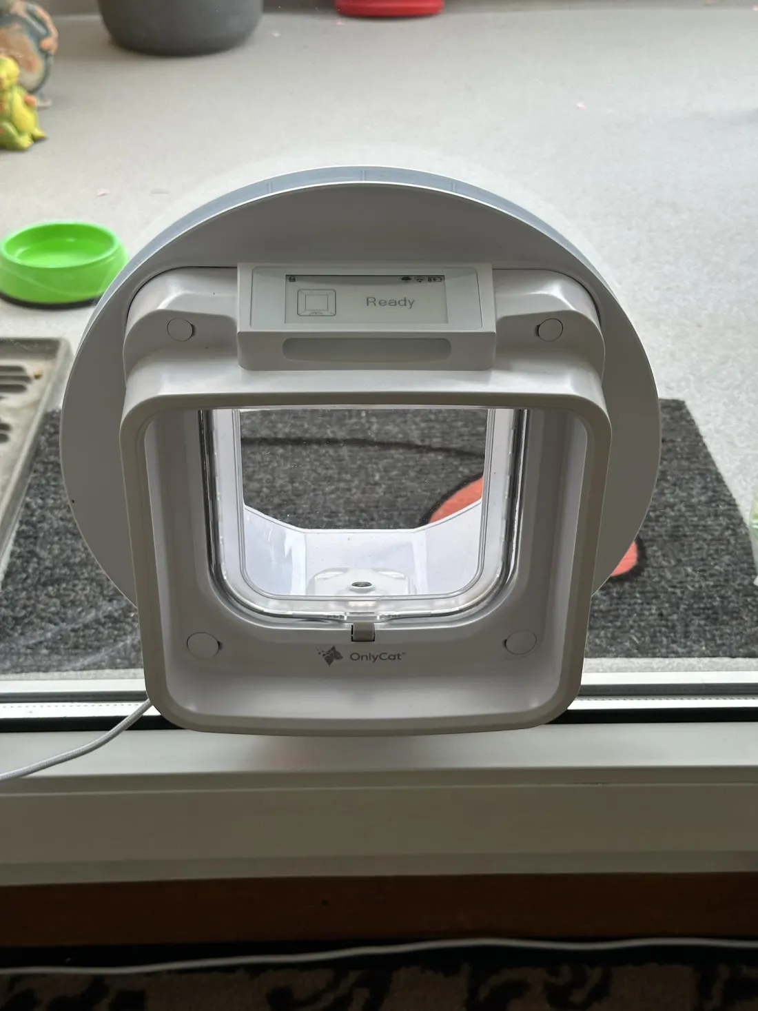 A customer’s OnlyCat fitted into glass with a circular mounting adaptor